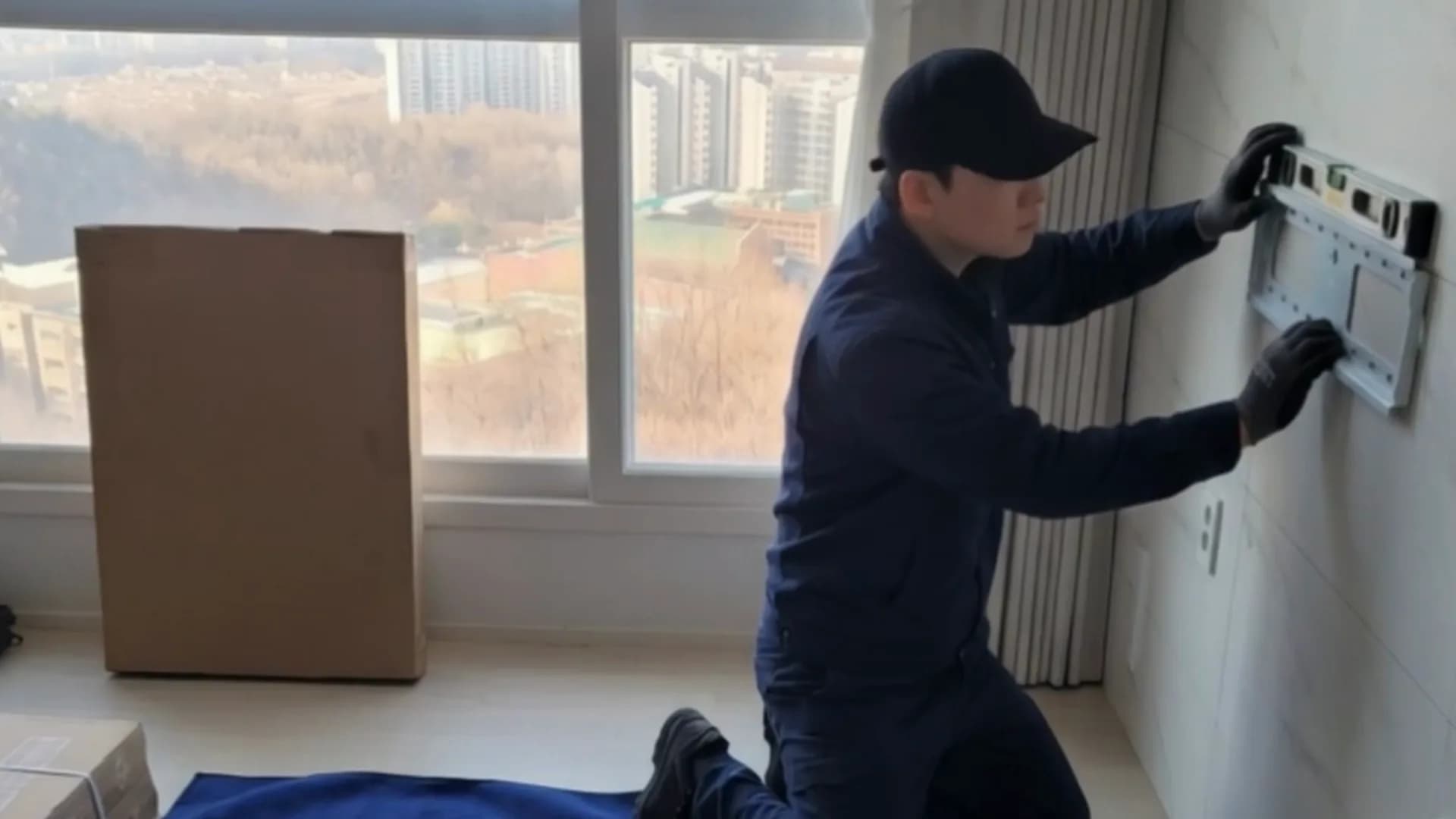 벽에 거치대를 설치하는 작업자